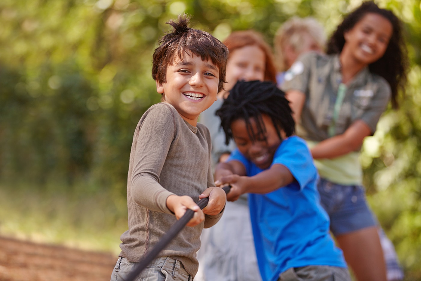 Learning teamwork through play. A group of kids in a tug-of-war game