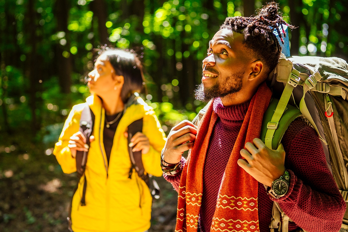 african american man and hispanic woman in a forest having a rest .