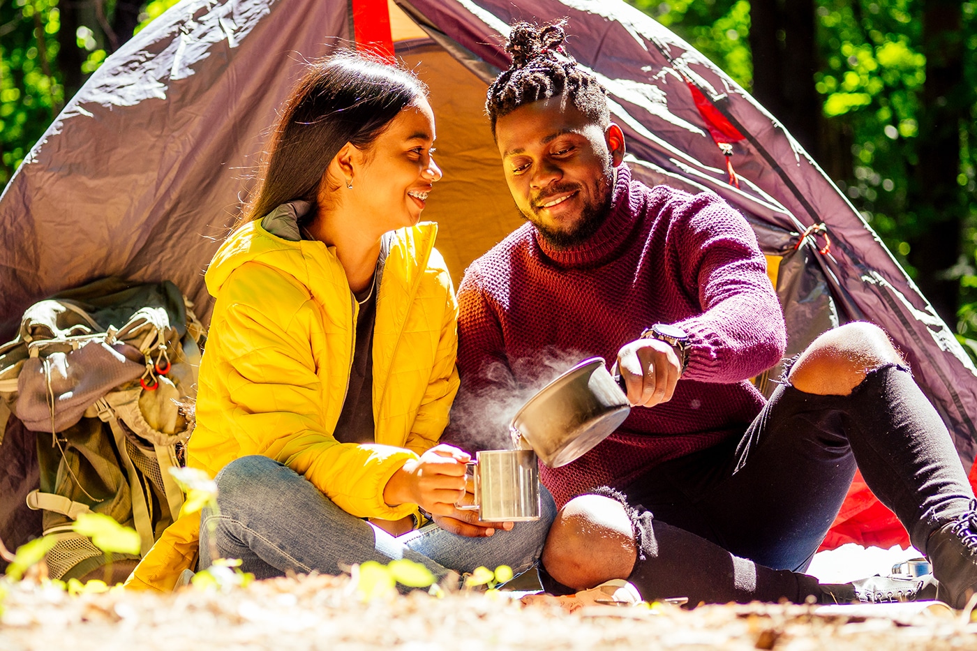 african american man and hispanic woman drinking tea , cooking food on a gas-burner .